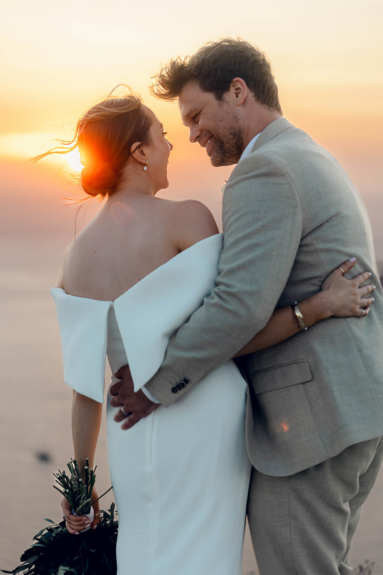Just married couple embracing at sunset after the wedding in Santorini