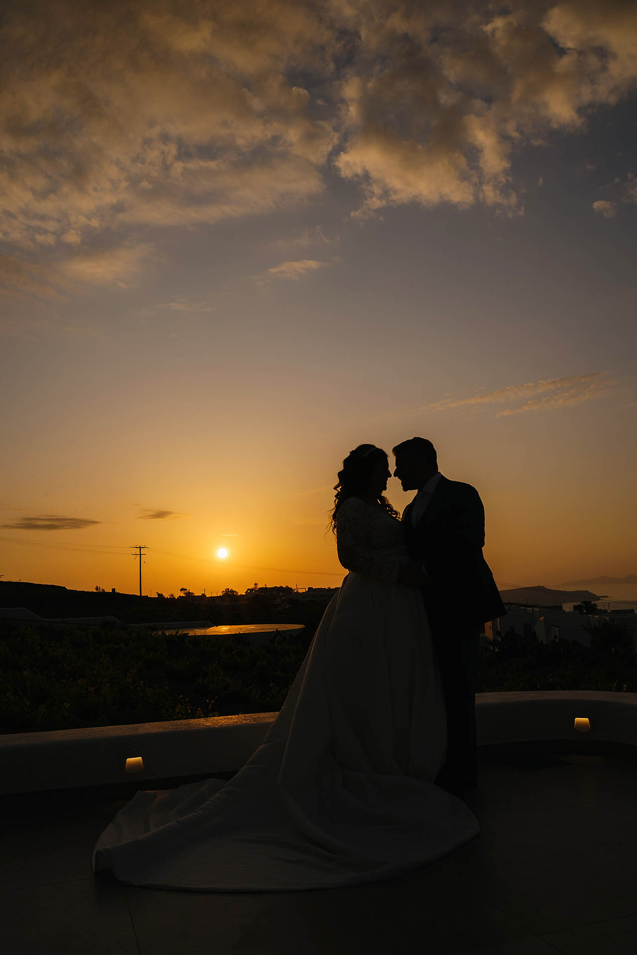 wedding while pregnant - a couple at the sunset in Santorini