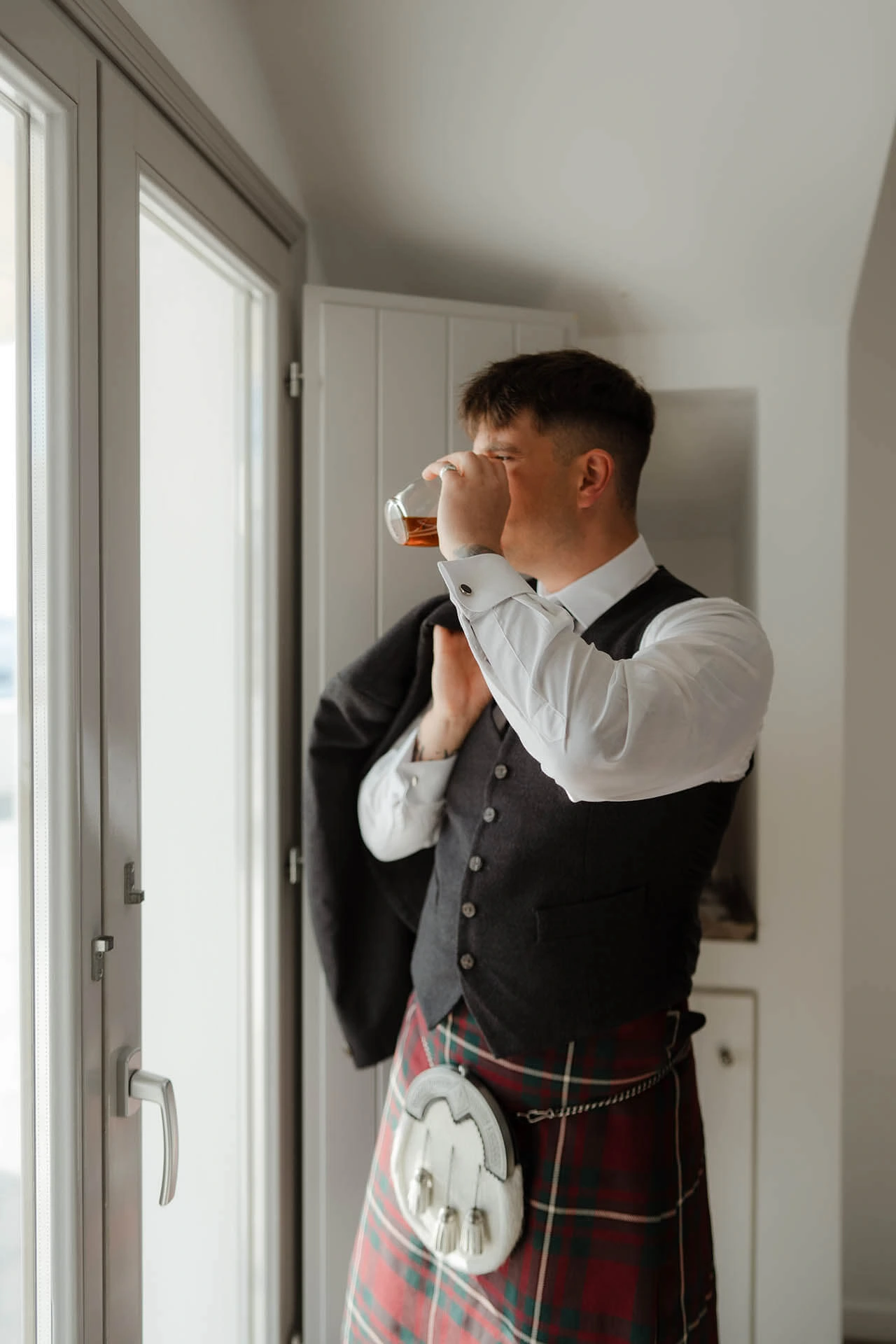 Multicultural Wedding in Santorini - scottish groom drinking whiskey - Marvellous Wedding
