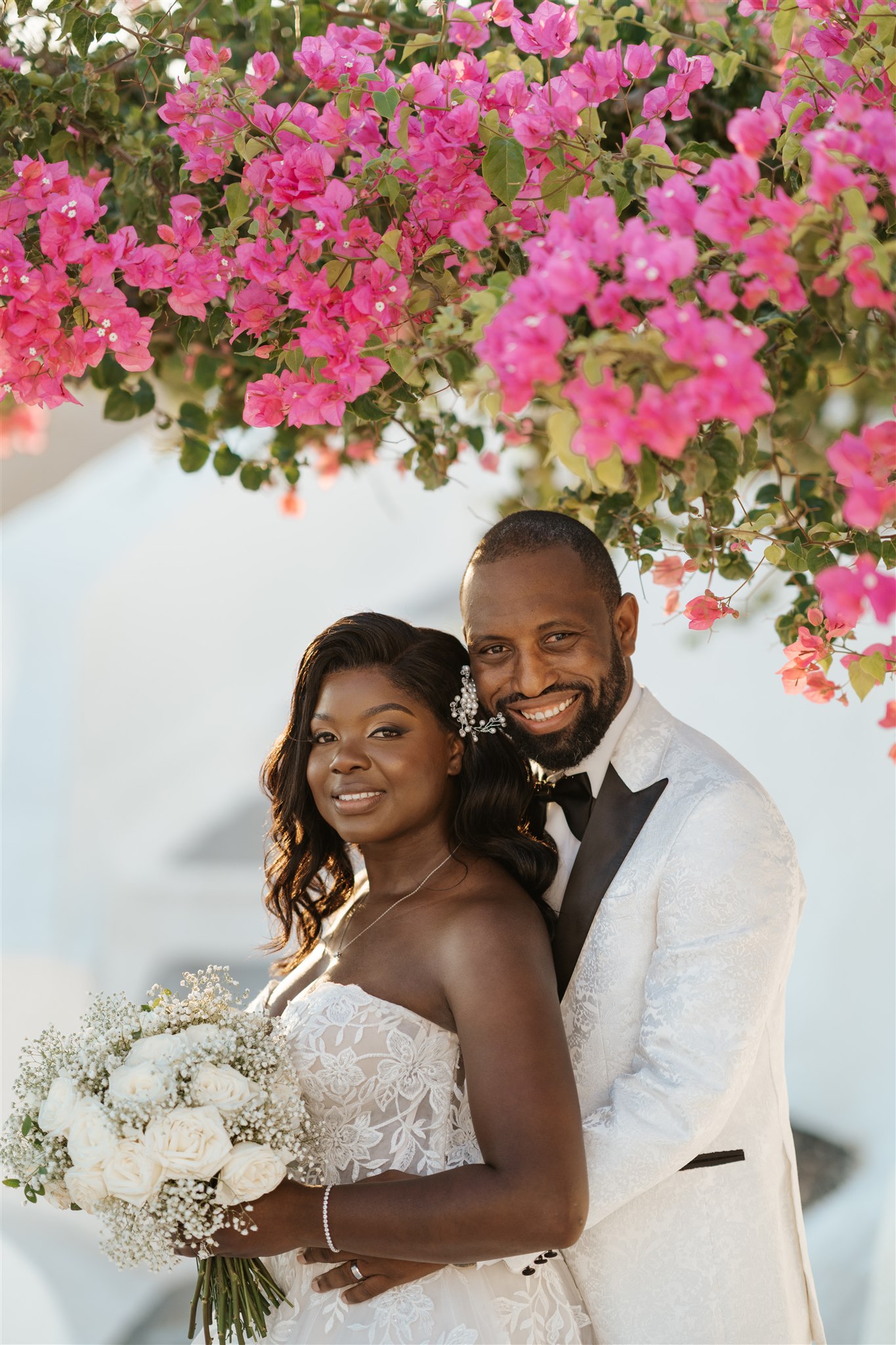 wedding at Dana Villas in Santorini - the couple in front of a Bougainvillea - Marvellous Wedding