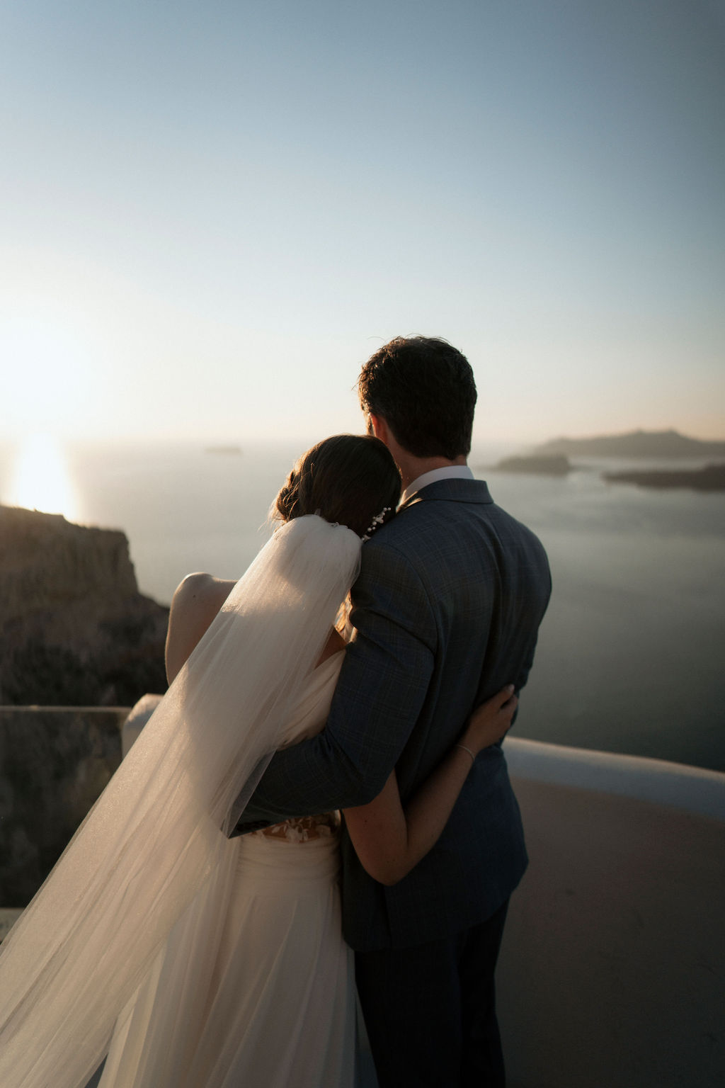 how to create wedding content - Hugged couple in front of the sunset at a Santorini wedding - Marvellous Wedding