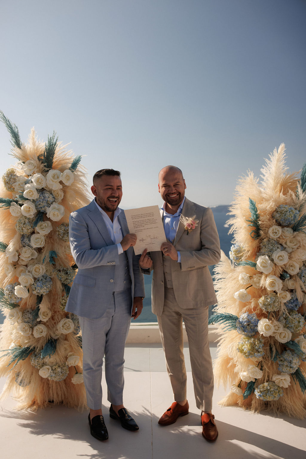Legal Documents for a Santorini Wedding - happy gay men holding their marriage certificate - Marvellous wedding