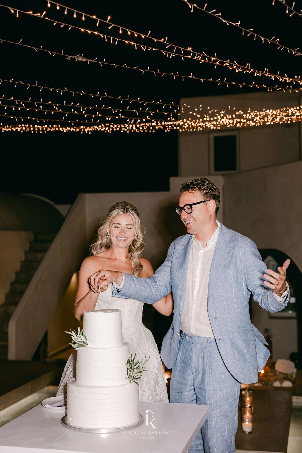 Greek Orthodox Wedding in Santorini - bride and groom cutting the wedding cake - Marvellous Wedding